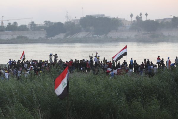 Irak, 5.11.2019: Demonstranten versammeln sich entlang des Tigris in Bagdad. Demonstrierende mit Fahnen am Fluss.