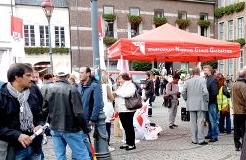 Zamek-Kolleginnen und -Kollegen vor dem Rathaus, dabei NGG mit Trans­pa­renten, Fahnen, Laut­sprecher und Schirm.