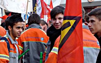 Junge Demonstranten mit IG-Metall-Fahnen und Tranparenten.
