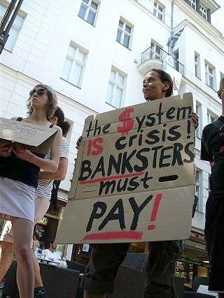 Demonstrantin mit Plakat: »the $ystem is crisis! Banksters must pay!«.